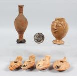 FOUR ROMAN TERRACOTTA OIL LAMPS, a small amphora style bottle, a figural pedestal jar and a