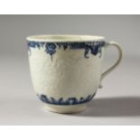 A WORCESTER BLUE AND WHITE FLORAL MOULDED COFFEE CUP, painted with two elaborate borders, crescent