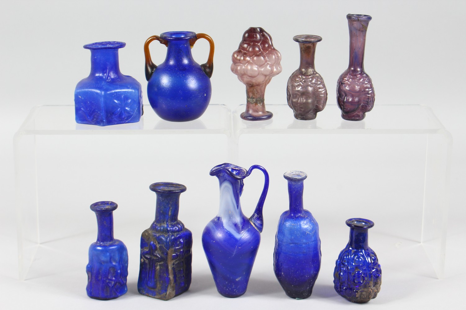 A COLLECTION OF ROMAN GLASS BOTTLES, some with moulded decoration as heads, bunches of grapes (10). - Image 6 of 10