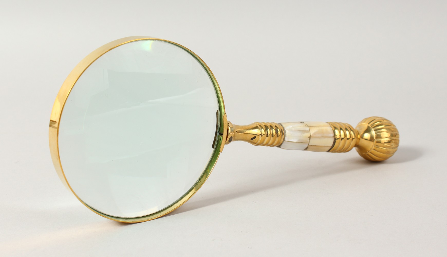 A MAGNIFYING GLASS with mother-of-pearl handle.