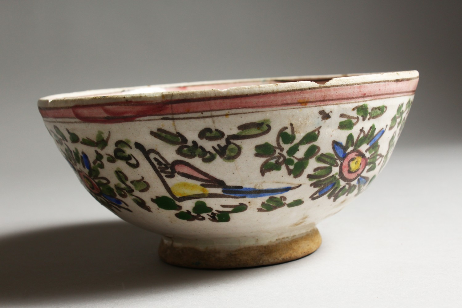 AN EARLY ISLAMIC POTTERY CIRCULAR BOWL, painted with birds. 7.5ins diameter.