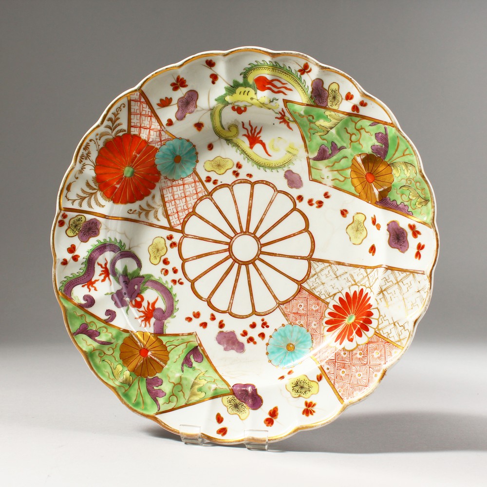 A WORCESTER COLOURED PLATE, painted with dragons, flowering prunus and chrysanthemums, rare gold