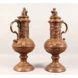 A LARGE PAIR OF CONTINENTAL EMBOSSED COPPER PEDESTAL EWERS, the hinged lids mounted with a lion