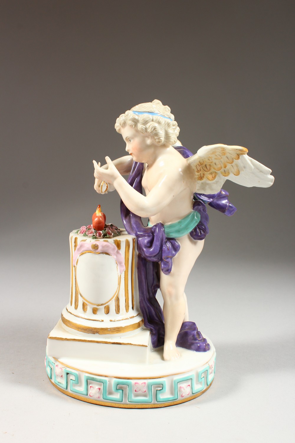 A CONTINENTAL GROUP OF A WINGED CUPID, symbolic of WINTER, standing before a column, on an oval - Image 3 of 6