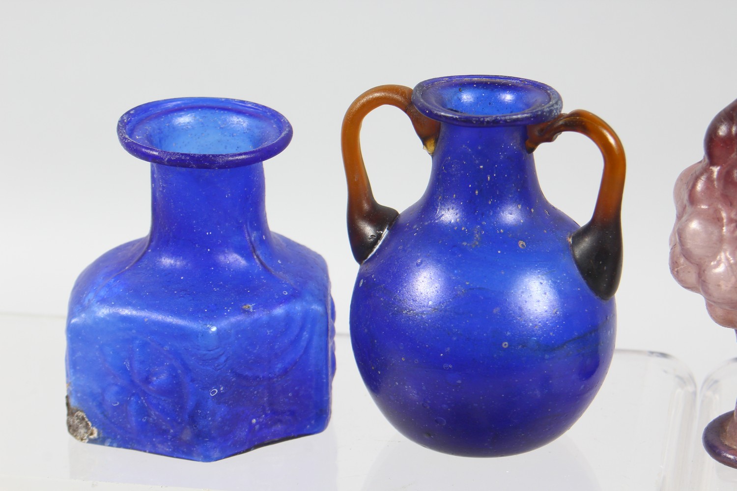 A COLLECTION OF ROMAN GLASS BOTTLES, some with moulded decoration as heads, bunches of grapes (10). - Image 2 of 10