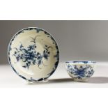 A WORCESTER BLUE AND WHITE TEA BOWL AND SAUCER, painted with large trailing flowers, the saucer with