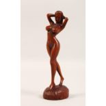A SMALL CARVED WOOD FIGURE, standing female nude. 7ins high.