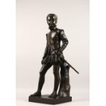 A PATINATED BRONZE FIGURE, LATE 19TH CENTURY, of a young male standing figure, his left hand on