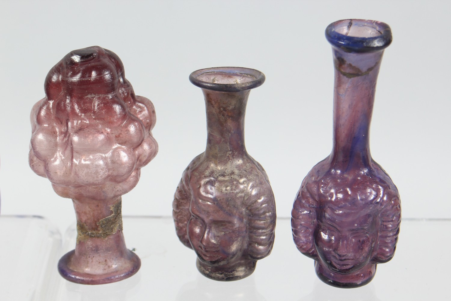 A COLLECTION OF ROMAN GLASS BOTTLES, some with moulded decoration as heads, bunches of grapes (10). - Image 3 of 10