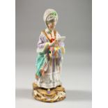 A MEISSEN FIGURE OF A LADY, standing with book in one hand, her other hand in a muff, crossed