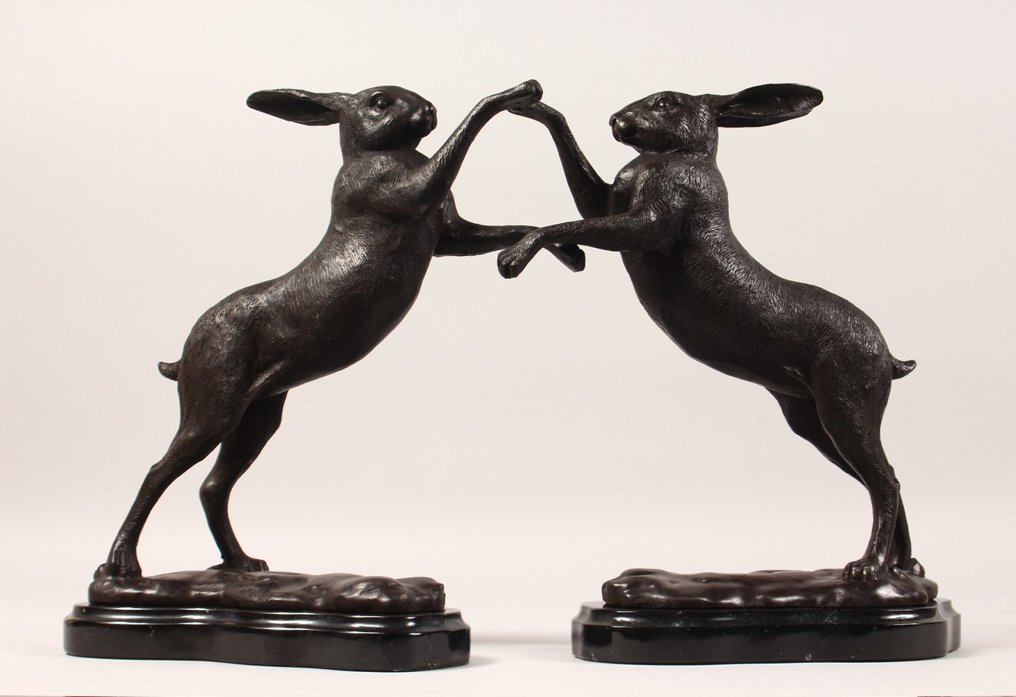 A SMALL PAIR OF BRONZE "BOXING HARES". 12ins high.