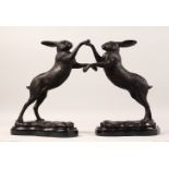 A SMALL PAIR OF BRONZE "BOXING HARES". 12ins high.