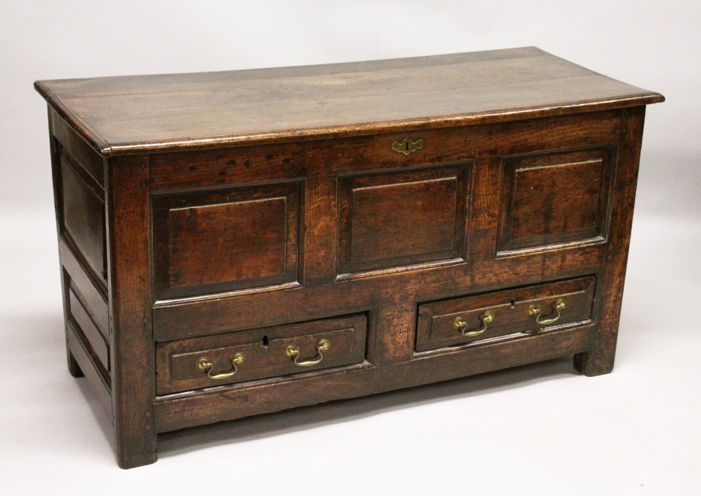 AN 18TH CENTURY OAK COFFER BACH, with rising top, panelled front and two drawers, on stile feet. 4ft