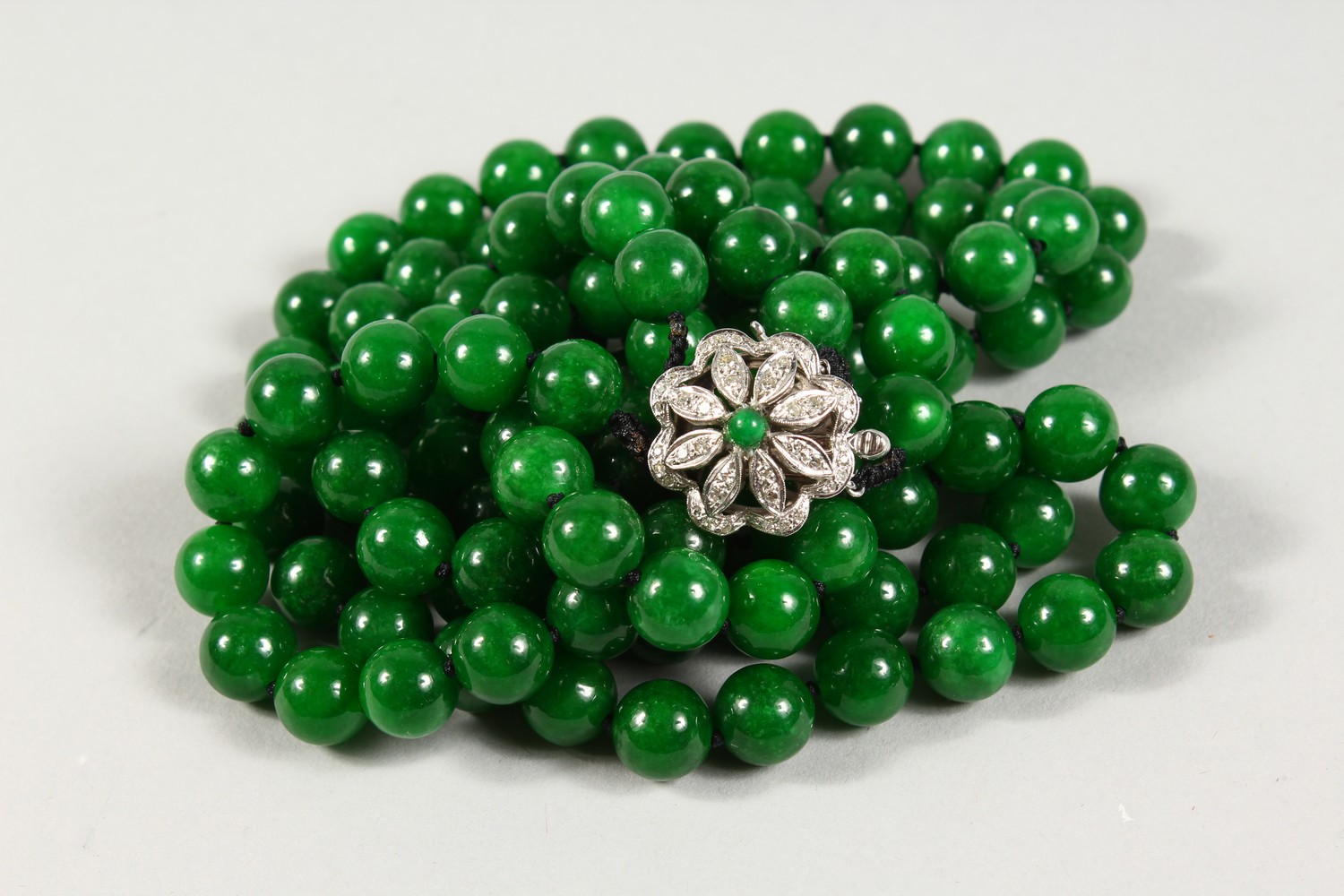 A GOOD DOUBLE ROW OF JADE BEADS, with 18ct white gold and diamond clasp. 25ins long. - Image 2 of 4