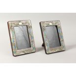 A PAIR OF ART NOUVEAU STYLE SILVER AND ENAMEL PHOTOGRAPH FRAMES. 7.5ins high x 5.75ins wide.