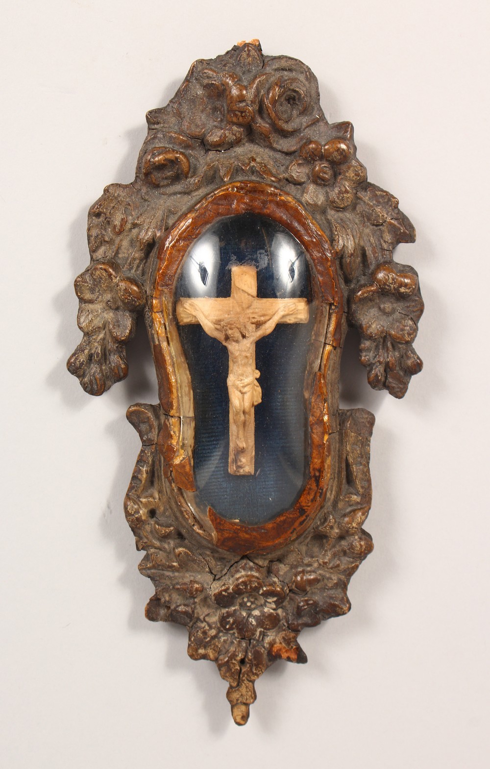 A SMALL 19TH CENTURY CARVED WOOD CORPUS CHRISTI, in a glazed, carved wood frame. 10ins high.