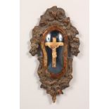 A SMALL 19TH CENTURY CARVED WOOD CORPUS CHRISTI, in a glazed, carved wood frame. 10ins high.