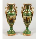 A PAIR OF SEVRES STYLE GREEN GROUND PEDESTAL VASES, decorated with figures and horses. 13ins high.