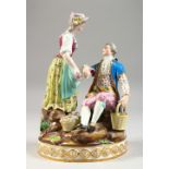 A MEISSEN GROUP OF A GENTLEMAN SEATED WITH A BASKET IN ONE HAND, a lady by his side with a bottle in