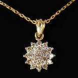 A 9CT GOLD DIAMOND CLUSTER PENDANT ON A CHAIN.