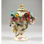 A MEISSEN PEDESTAL VASE AND COVER, decorated with cherubs and floral swags. 8ins high.