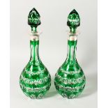 A PAIR OF GREEN CUT GLASS DECANTERS, with silver collars, Mappin & Webb, London 1964. 15ins high.