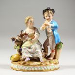 A GOOD SMALL MEISSEN GROUP OF A BOY AND GIRL, the boy standing playing a pipe, the girl seated by