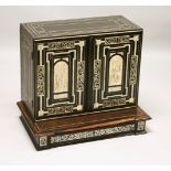 AN IVORY INLAID EBONY TABLE CABINET, the pair of doors inlaid with ached panels decorated with