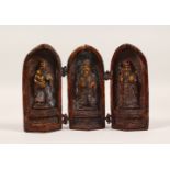 A BRONZE FOLDING TRYPTICH, containing three gods. 5.5ins high.