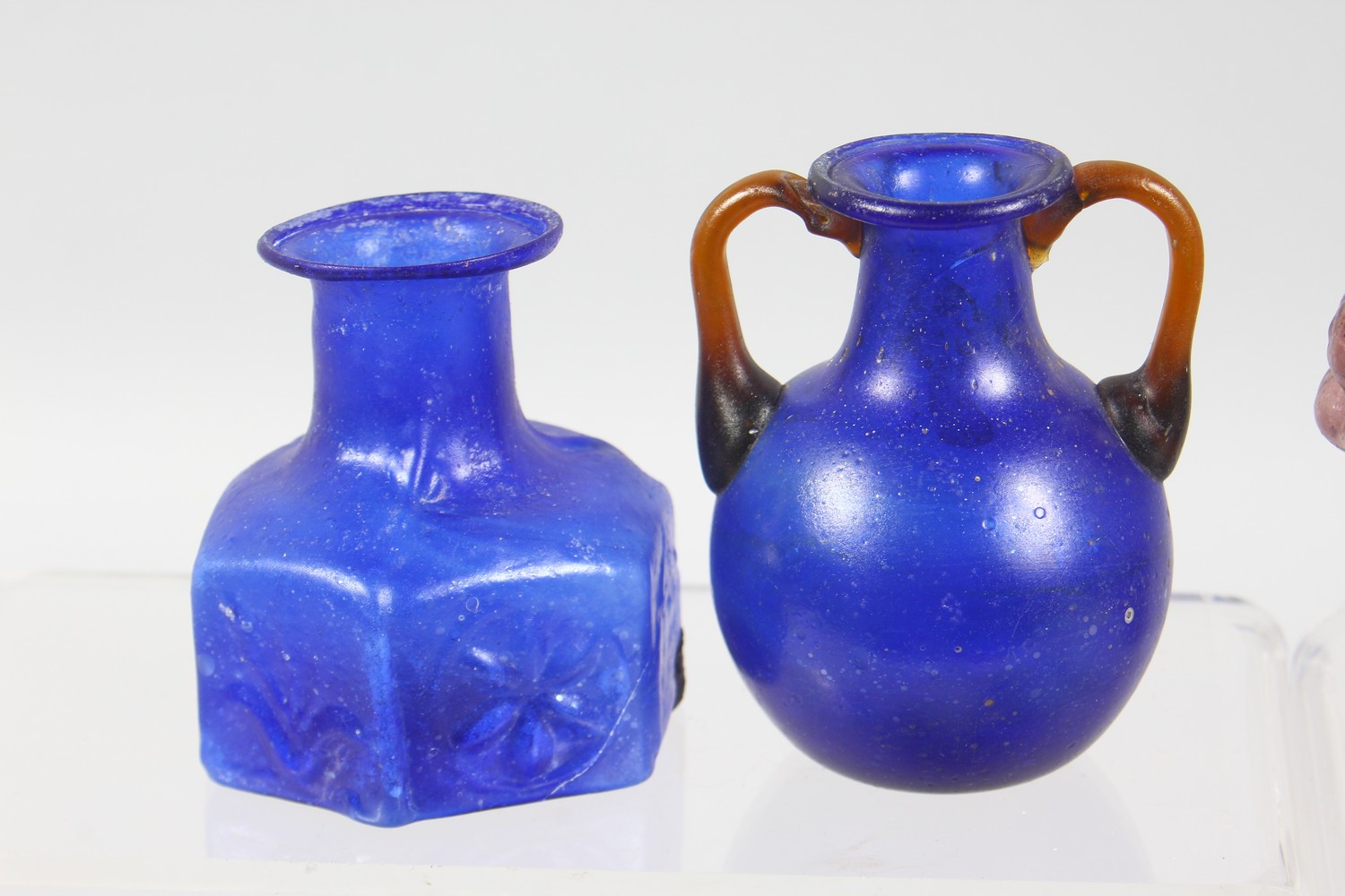 A COLLECTION OF ROMAN GLASS BOTTLES, some with moulded decoration as heads, bunches of grapes (10). - Image 7 of 10