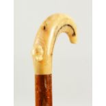 A WALKING STICK with simulated-bone handle. 2ft 1in long.