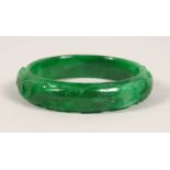 A CARVED APPLE GREEN JADE BANGLE. 3ins diameter.