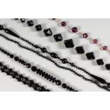 FIVE BLACK GLASS BEAD NECKLACES.