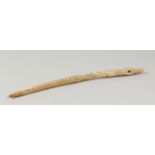 AN ESKIMO WHALEBONE TOOL, possibly a fishing net needle. 15ins long.