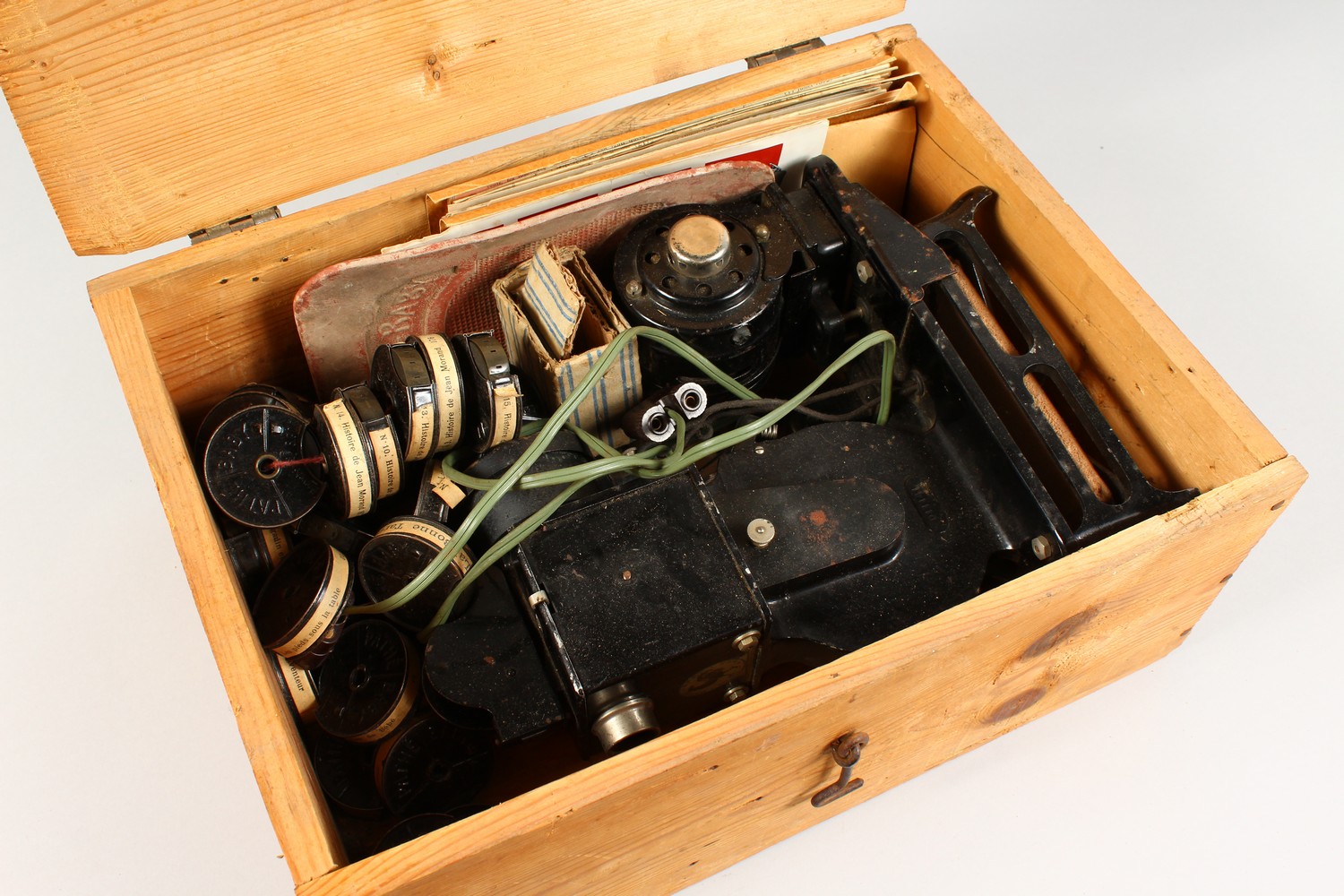 AN EARLY ELECTRIC FILM PROJECTOR, with a quantity of film rolls.