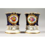 A PAIR OF MEISSEN SMALL SPILL VASES, blue ground, painted with a panel of flowers on scrolling