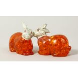 A PAIR OF AMBER RABBITS with plated heads. 2.5ins long.