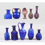 A COLLECTION OF ROMAN GLASS BOTTLES, some with moulded decoration as heads, bunches of grapes (10).