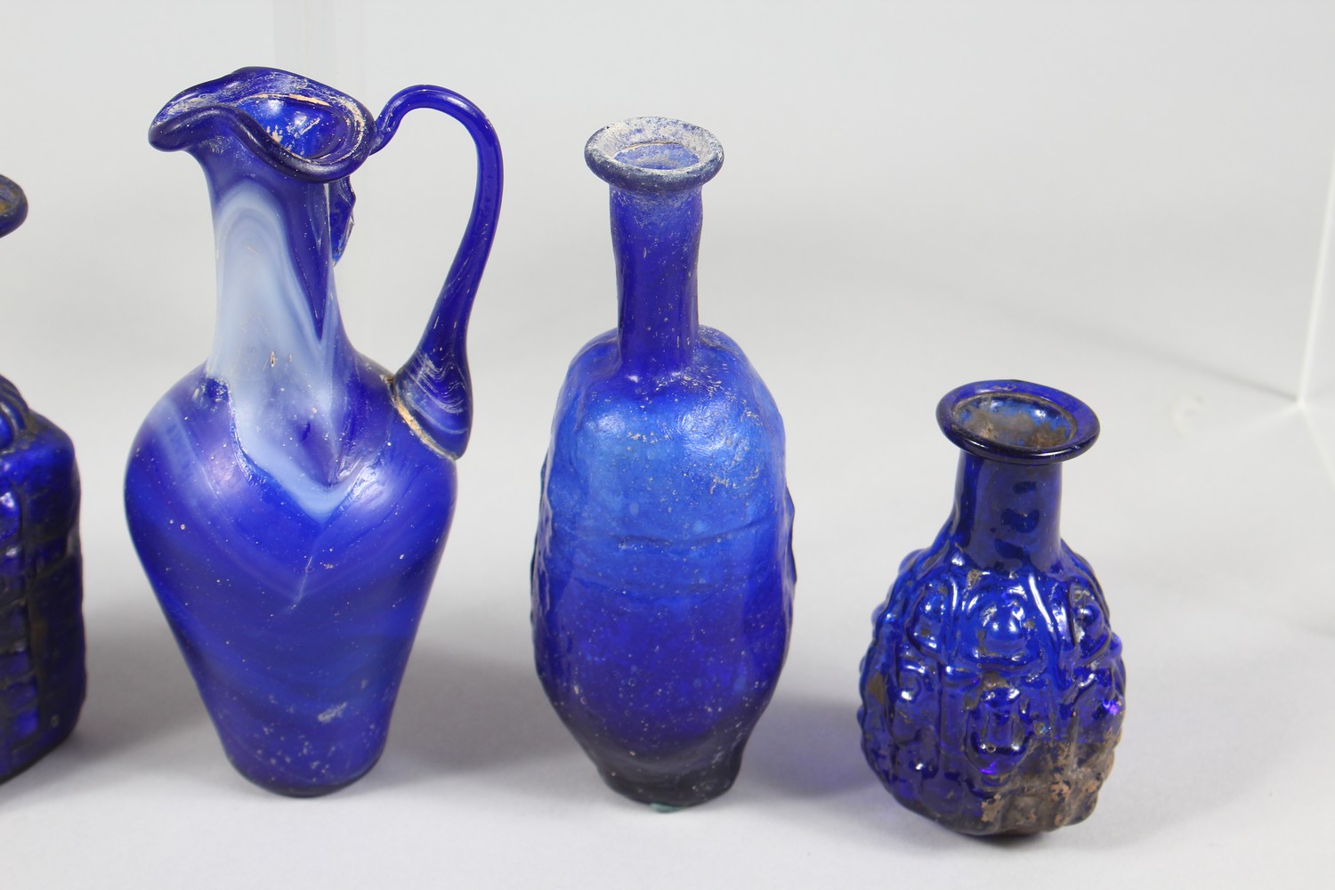 A COLLECTION OF ROMAN GLASS BOTTLES, some with moulded decoration as heads, bunches of grapes (10). - Image 9 of 10