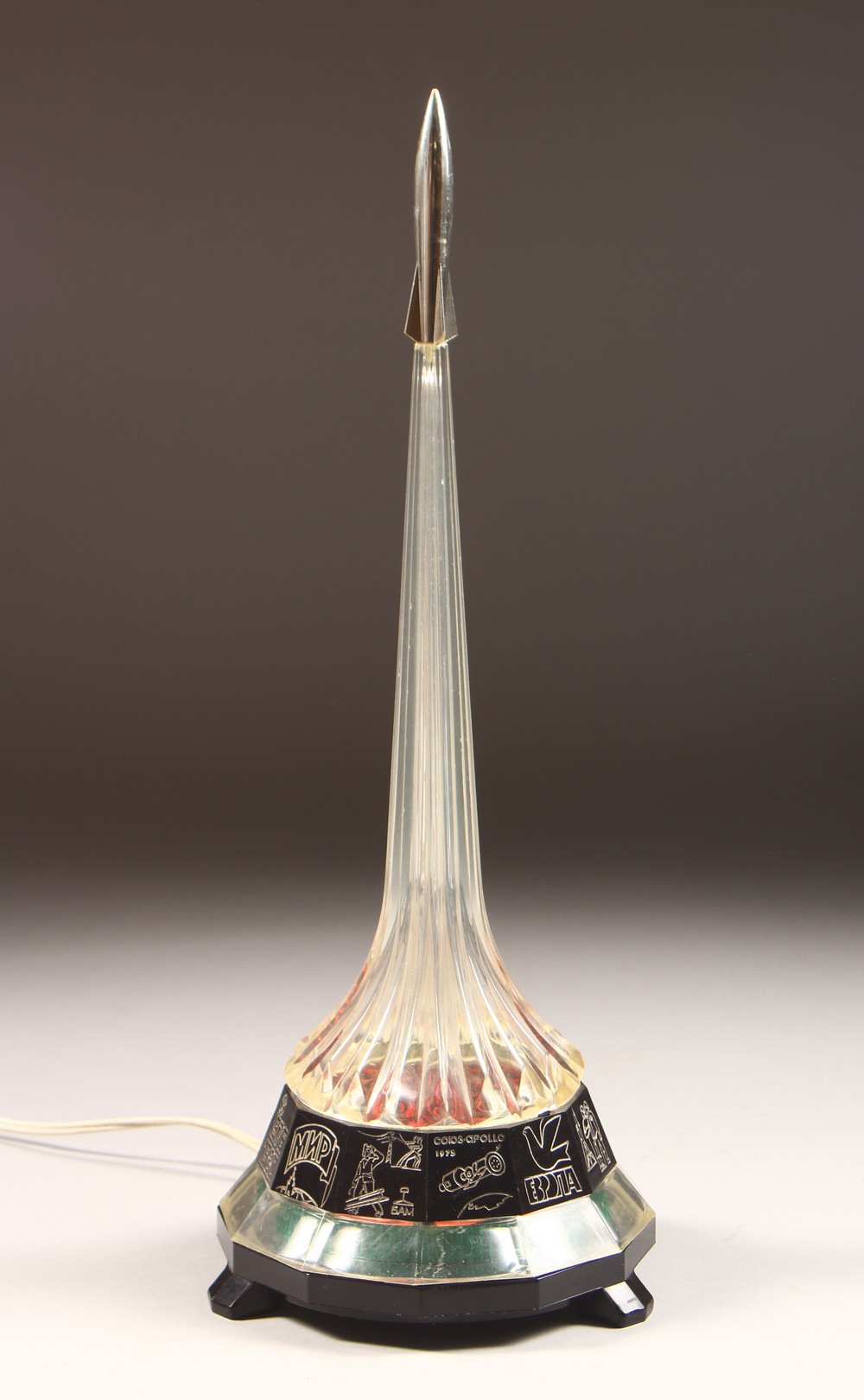 AN UNUSUAL RUSSIAN COMMEMORATIVE TABLE LAMP, of spire shape with rocket finial, dated 1976-1980.