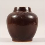 A BROWN POTTERY GLOBULAR SHAPED VASE. 7.5ins high.