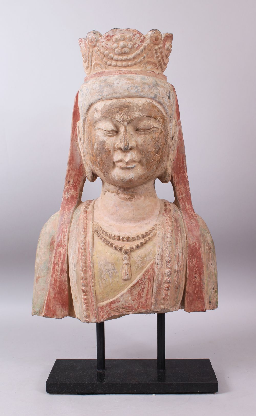 A 19TH / 20TH CENTURY SANDSTONE BUST OF BUDDHA wearing a headdress, with polychrome decoration, on