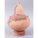 AN EASTERN TERRACOTTA CIRCULAR VESSEL WITH NARROW NECK ON A CIRCULAR BASE, 27cm high x 20cm wide.