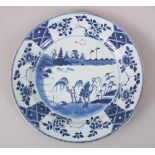 A LARGER THAN NORMAL CHINESE KANGXI PERIOD PORCELAIN PLATE, with scenes of lakeside settings, with