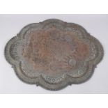 A LARGE INDIAN COPPER EMBOSSED TRAY with carved and embossed decoration, 69cm x 54cm.