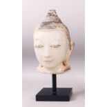 A 19TH CENTURY CARVED WHITE MARBLE BURMESE BUDDHA HEAD with painted headdress, on a pedestal base.