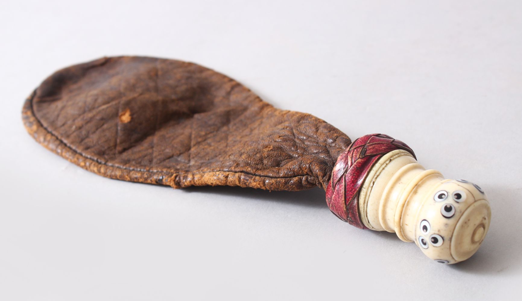 AN UNUSUAL POSSIBLY TURKISH OTTOMAN LEATHER POWDER FLASK, the carved bone handle with inlaid with