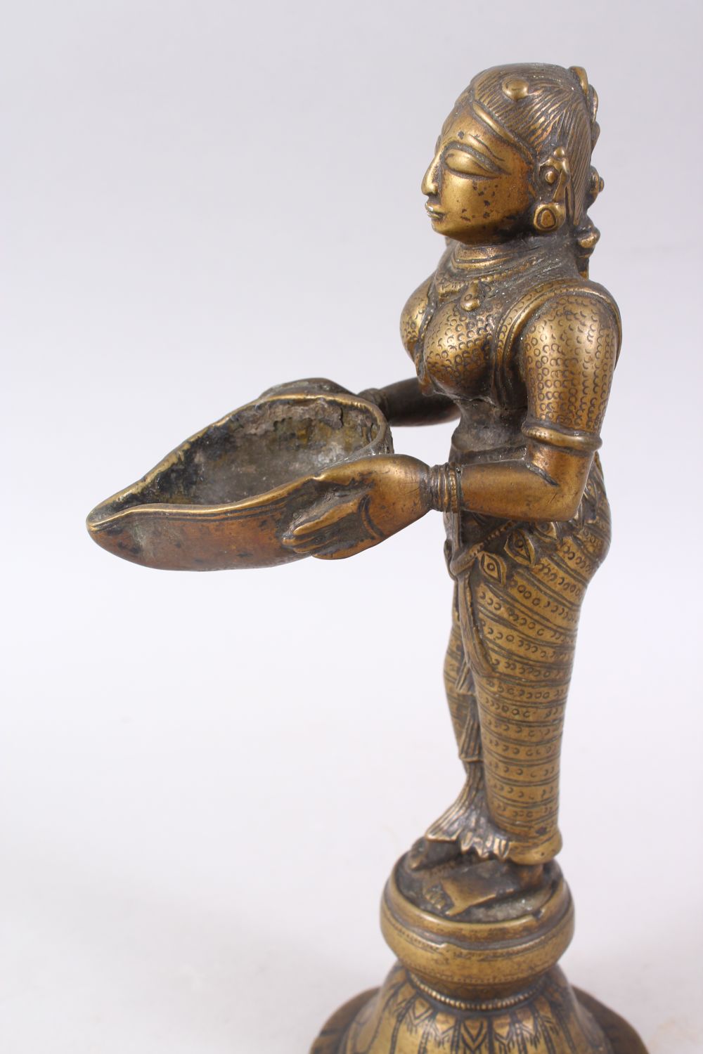 AN 18TH CENTURY INDIAN BRONZE OIL LAMP FIGURE OF LAKSHMI, stood on plinth holding a dish, 27cm - Image 4 of 6