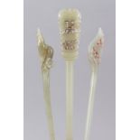 THREE 19TH / 20TH CENTURY CHINESE CARVED JADE HAIR PINS, each with a carved top, 19.5cm, 16cm & 15.