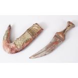 A GOOD PERSIAN JAMBYA DAGGER, the sheath formed from white metal and leather, the handle formed from